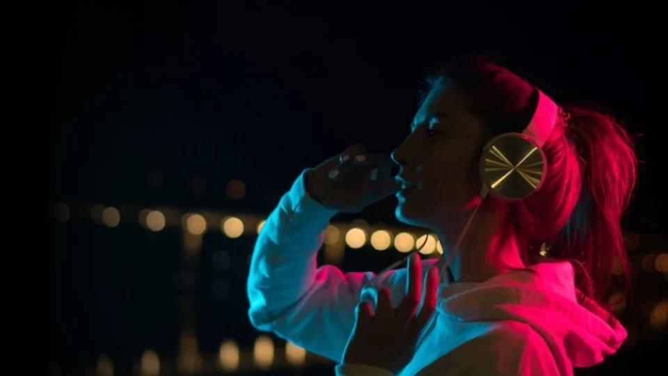 A young woman with headphones on her head looking away